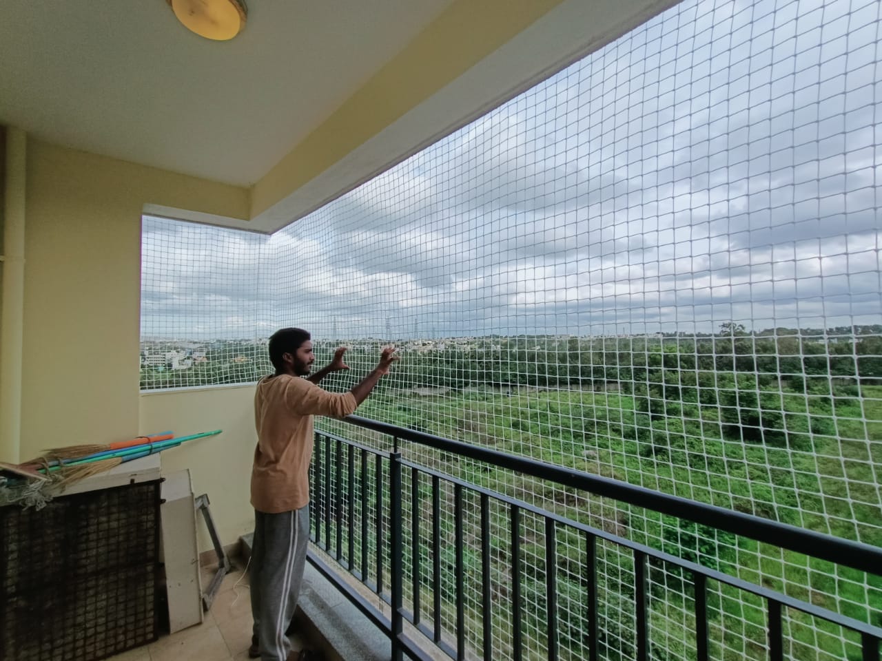 An installer checking mesh netting across a balcony